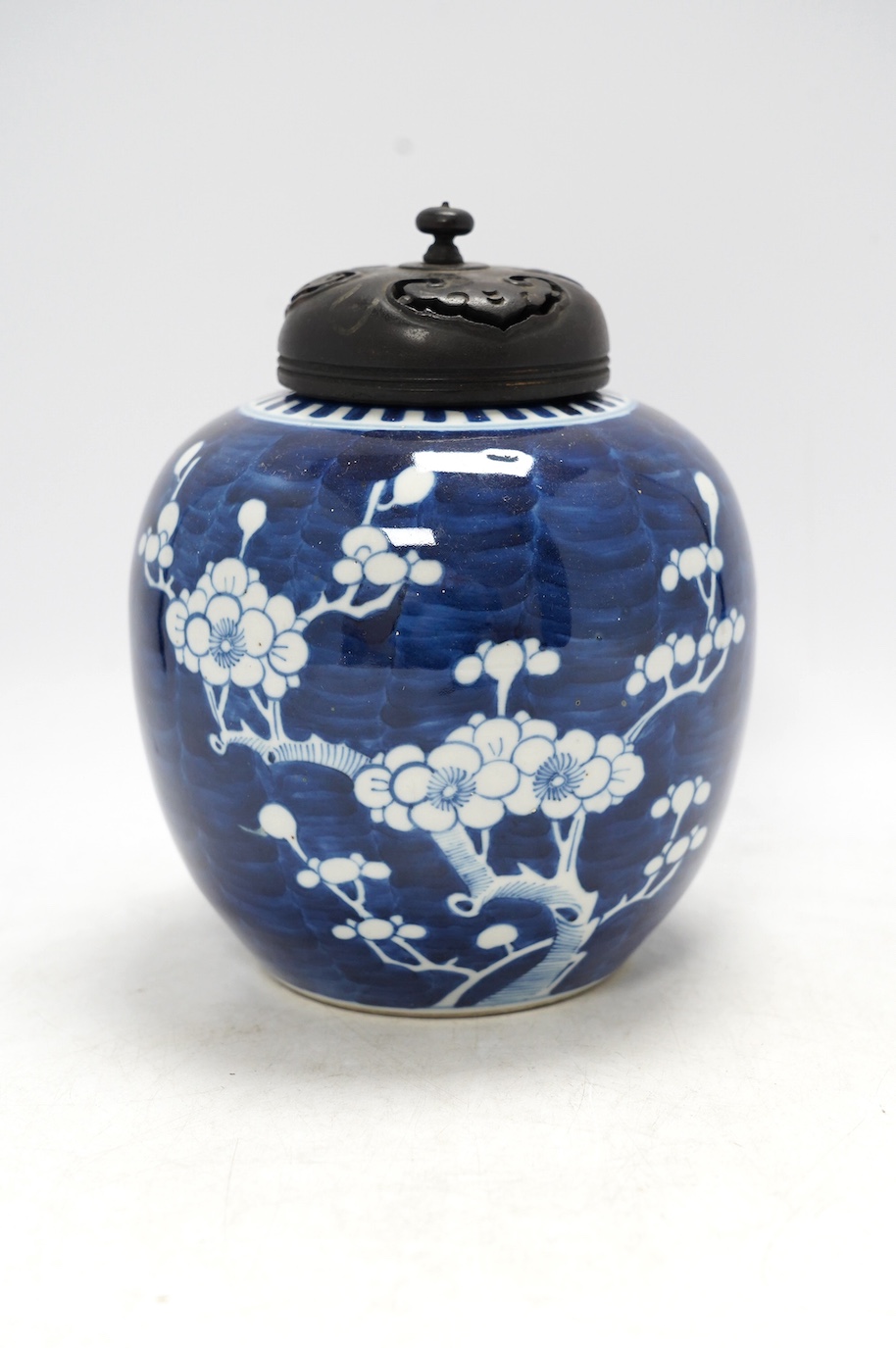 A Chinese blue and white prunus jar, with wood cover, early 20th century, 20.5cm high. Condition - good.